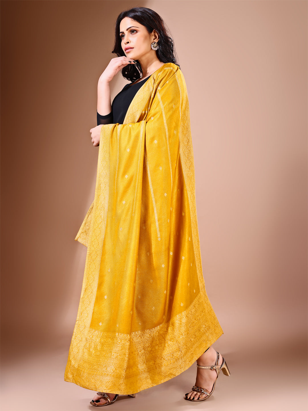 Model in a fancy pose wearing a mustard Banarasi bridal dupatta, ideal for wedding wear.