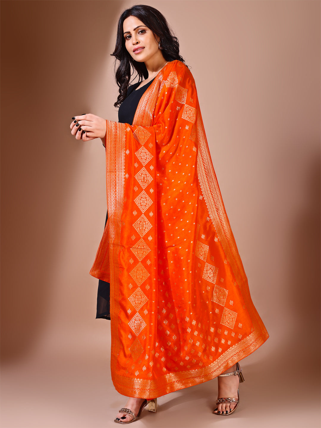 Close-up shot of orange Banarasi bridal dupatta with intricate zari work, perfect for weddings.