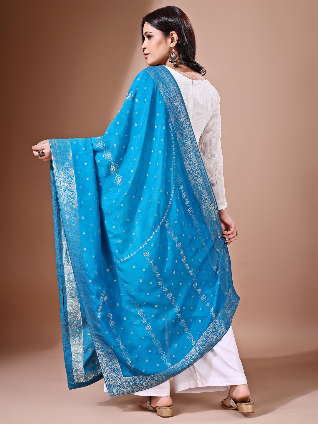 Model in a fancy pose wearing a rama blue Banarasi bridal dupatta, ideal for wedding wear.