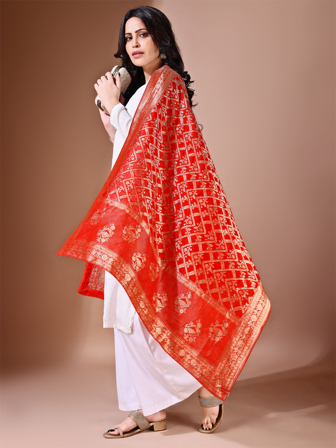 Close-up shot of rust Banarasi bridal dupatta with intricate zari work, perfect for weddings.