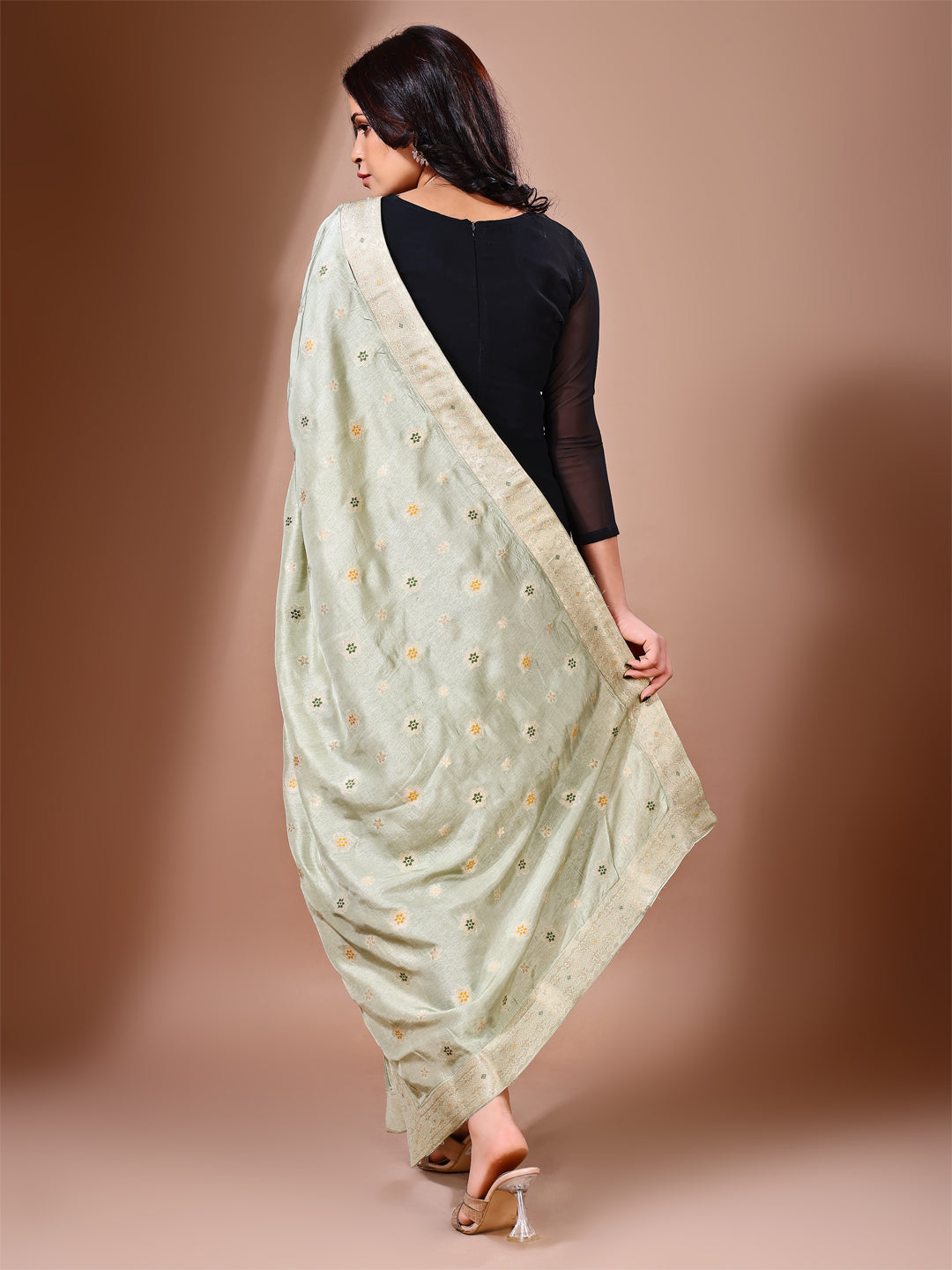 Model in a fancy pose wearing a green Banarasi bridal dupatta, ideal for wedding wear.