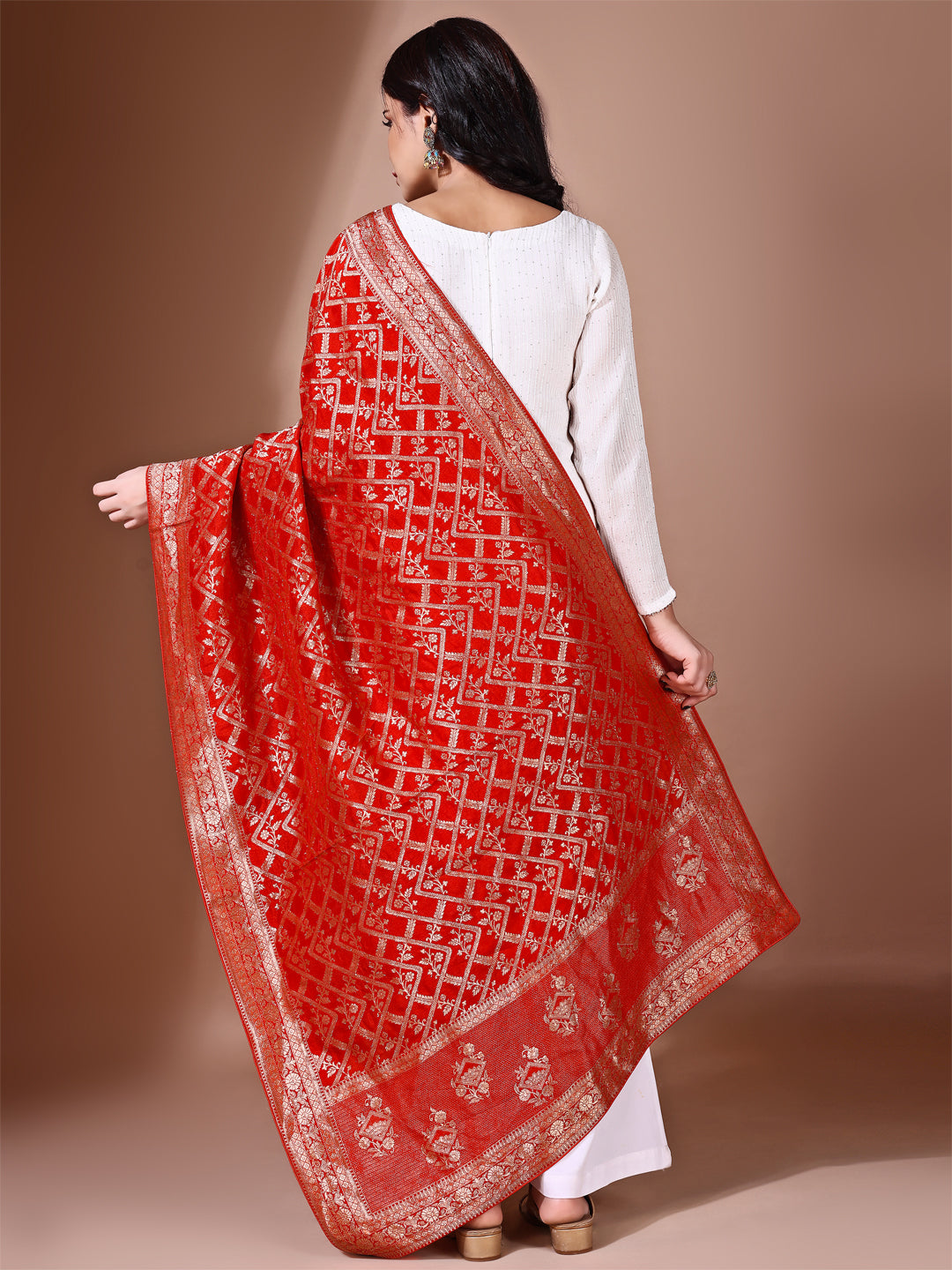 Model in a fancy pose wearing a rust Banarasi bridal dupatta, ideal for wedding wear.