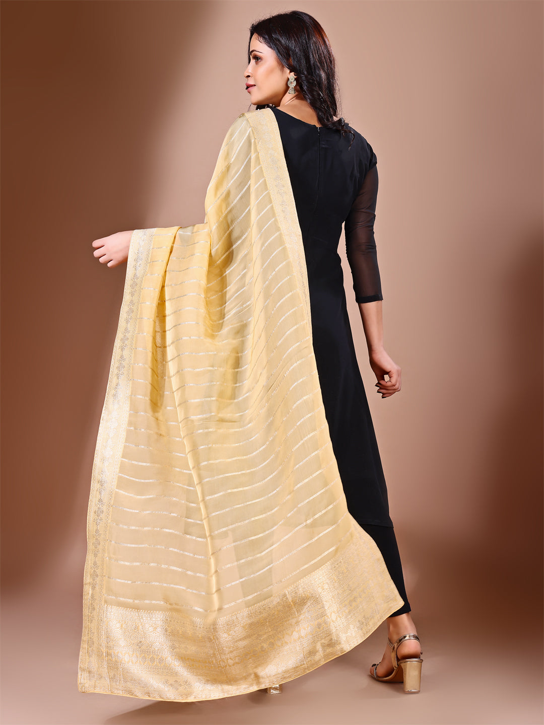 Model in a fancy pose wearing a yellow Banarasi bridal dupatta, ideal for wedding wear.